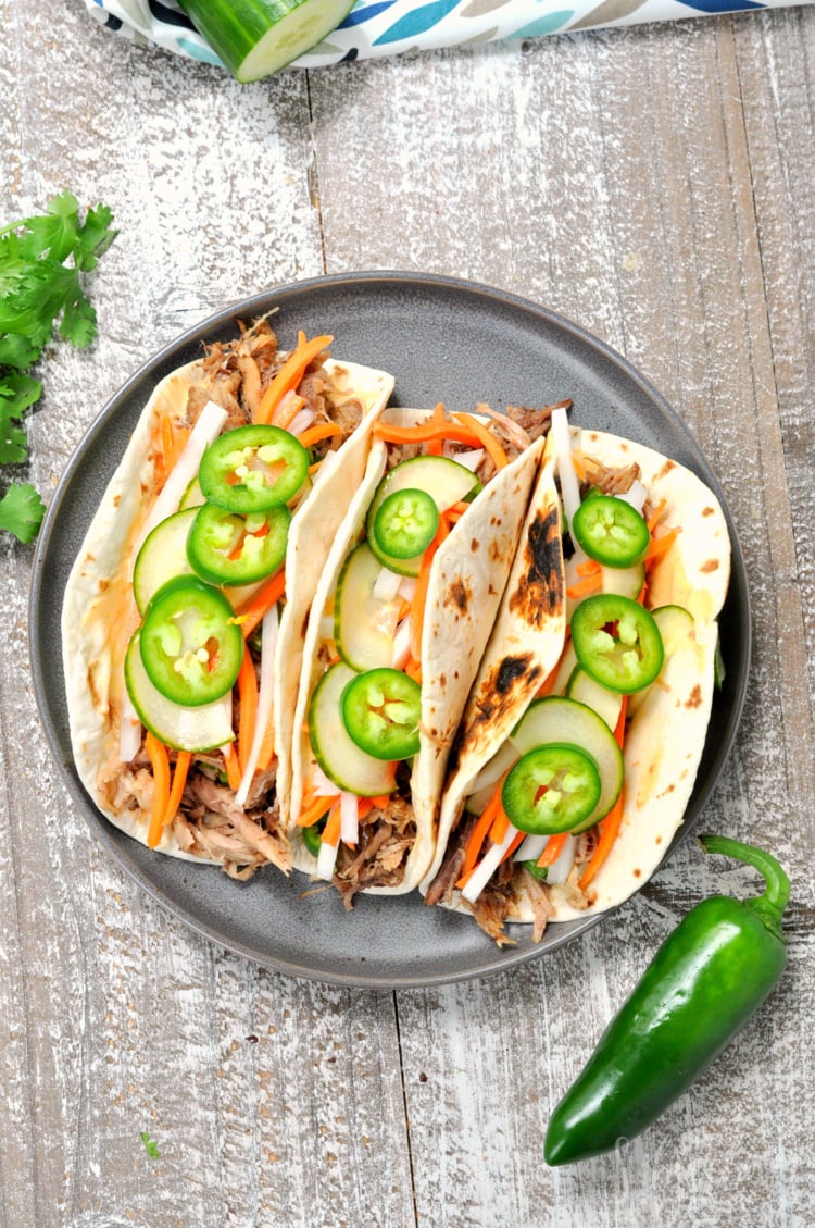 Flat lay view of three Vietnamese Pork Banh Mi Tacos on plate