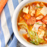 Best Cabbage Soup Recipe - Overhead photo of cabbage soup in bowl with carrots to left of bowl