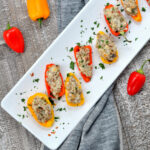 Sausage Stuffed Mini Peppers on white serving dish with gray napkin