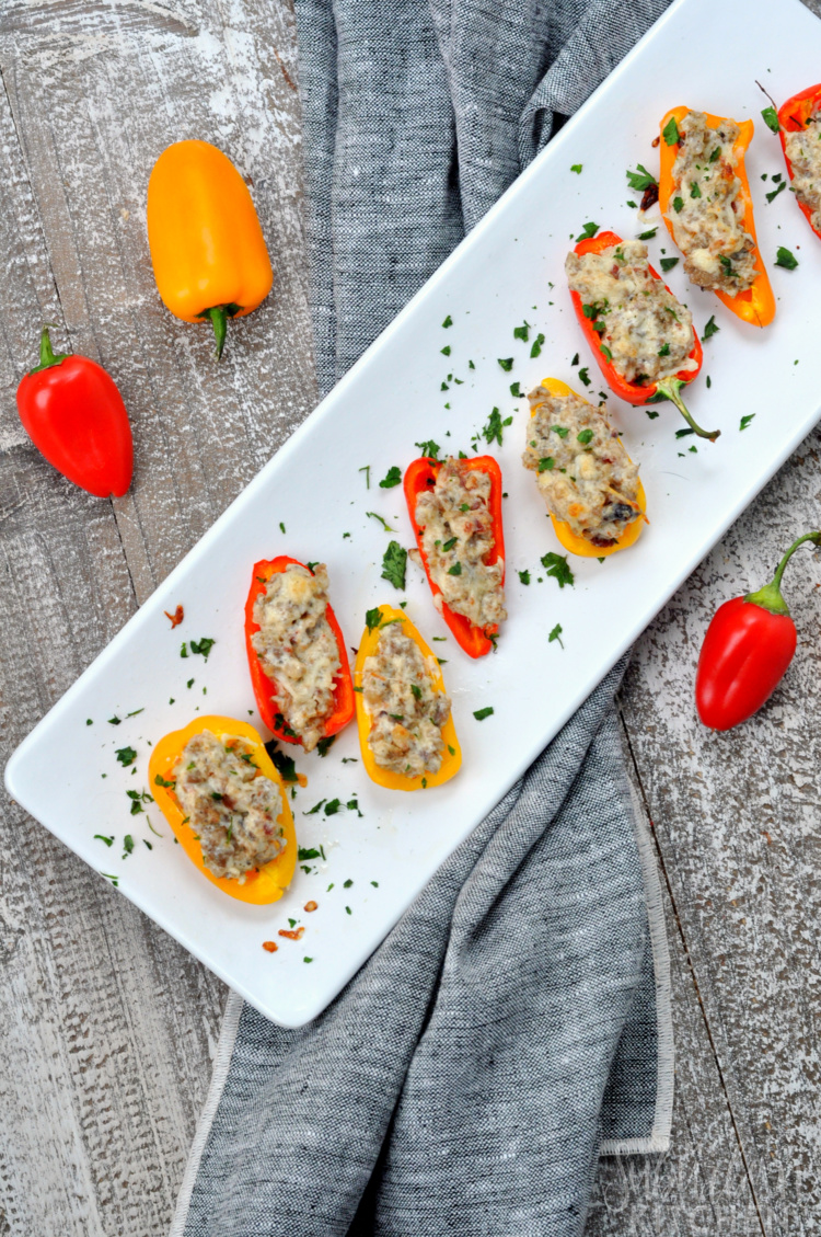 Sausage Stuffed Mini Peppers on white serving dish with gray napkin