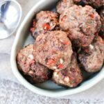 Meatballs cooking in air fryer with gyro seasoning