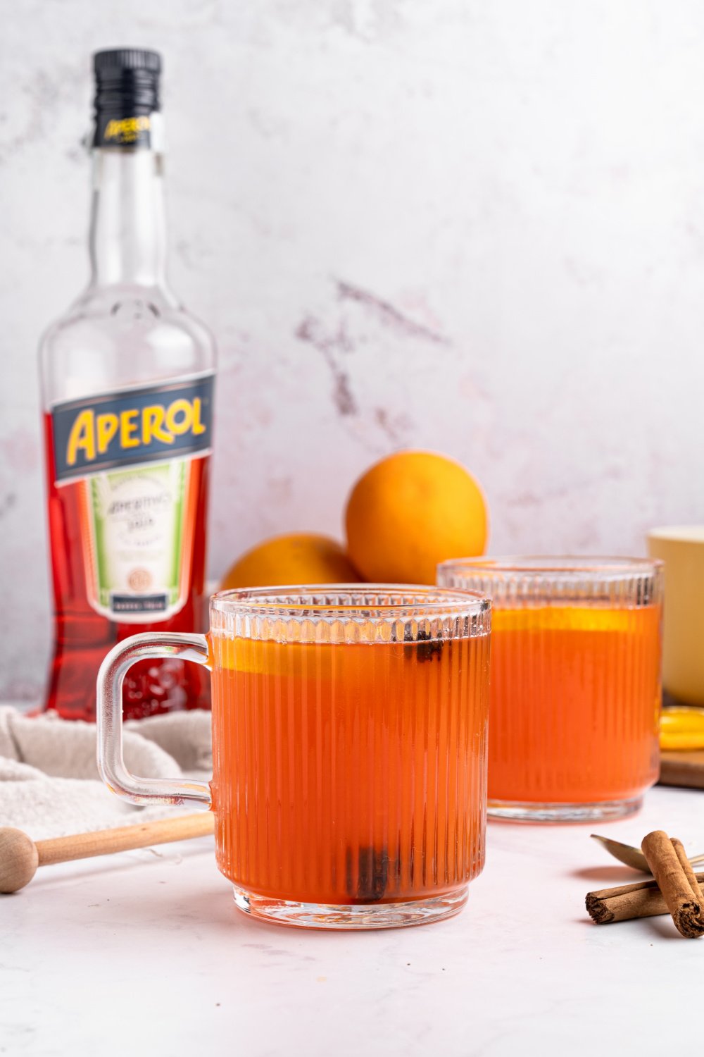 hot Aperol spritz recipe in glasses with Aperol bottle visible